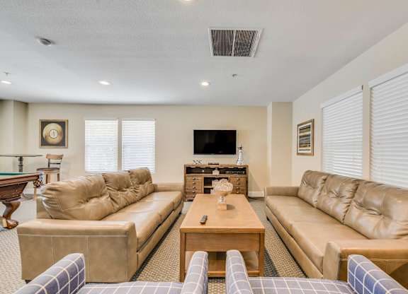 A living room with a pool table and a television.