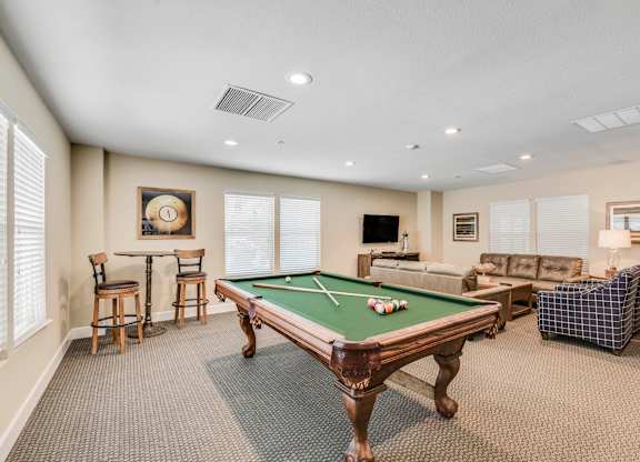 A room with a pool table and a couch.