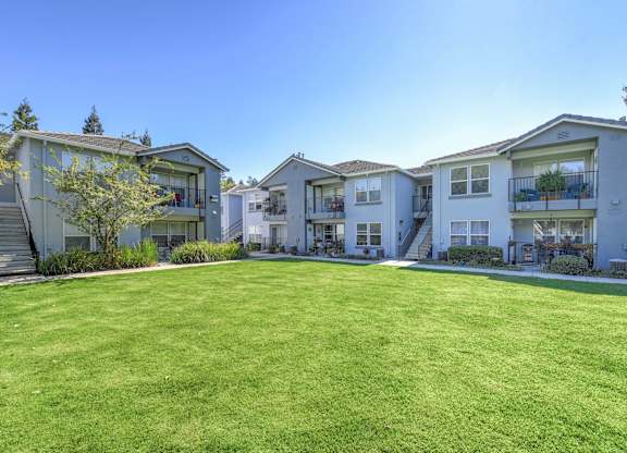 A large grassy area in front of apartment buildings.