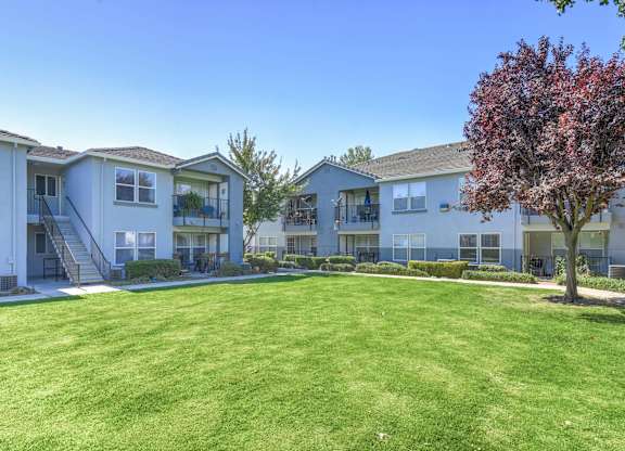 A grassy area in front of apartment buildings.