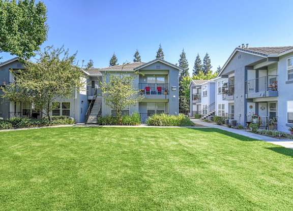 A grassy area in front of apartment buildings.
