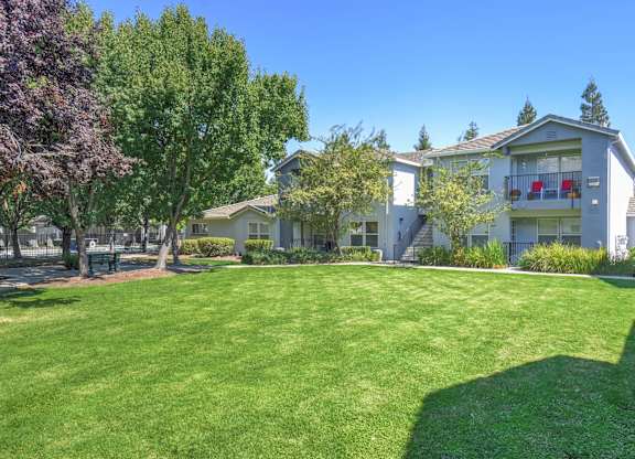 A large grassy area in front of apartment buildings.