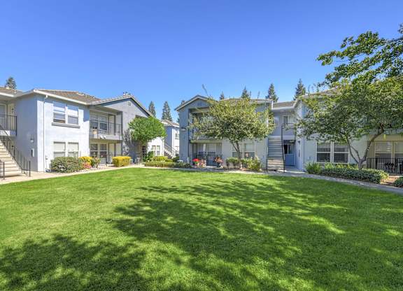 A sunny day at a residential area with houses and green lawns.