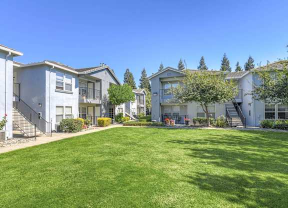 A row of houses with green lawns in front.