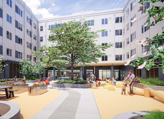 A courtyard with a large tree in the center and people sitting on benches at Rivo Apartments, California, 95815