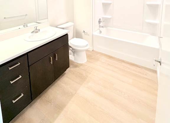 A white bathroom with a toilet, sink, and bathtub.