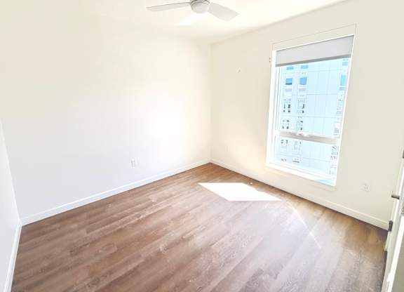 A room with a ceiling fan and a window showing a calendar.