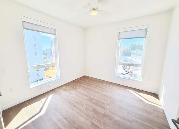 A room with a window overlooking a parking lot.