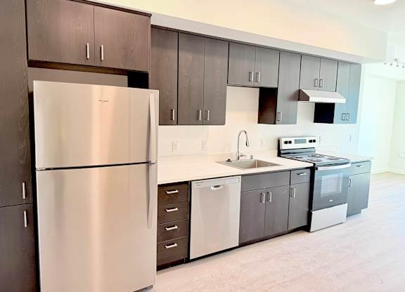 A modern kitchen with a stainless steel refrigerator and a white countertop.