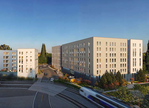 A modern building complex with a road in front of it.