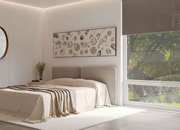 A bedroom with a large bed and a chair.