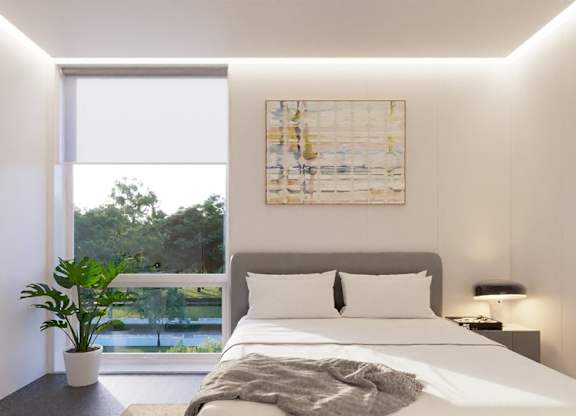 A bedroom with a large bed and a large window.
