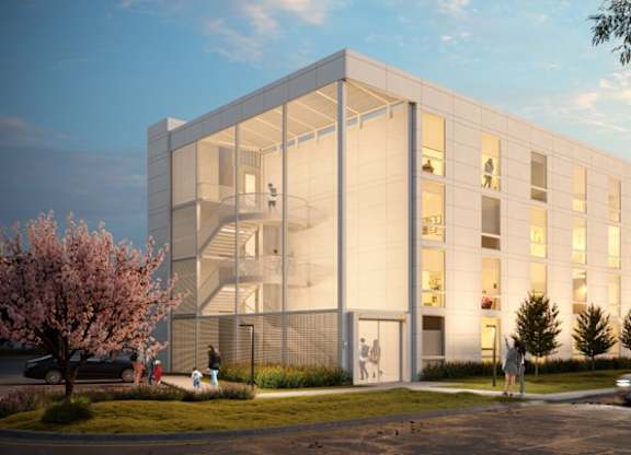 A modern building with a lot of windows and a car driving by.