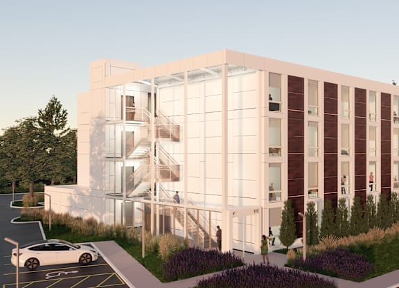 A modern building with a white car parked in front.