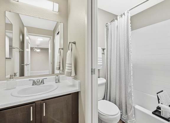 A white bathroom with a sink, toilet, and bathtub.