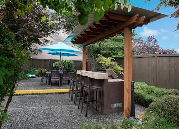 A patio with a table and chairs under a blue umbrella.