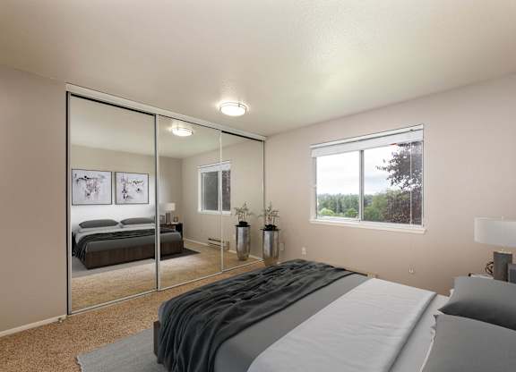 A bedroom with a large bed and a mirror on the wall.