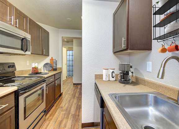 A kitchen with a stove, microwave, and oven.