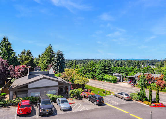 A parking lot with cars and a building in the background.