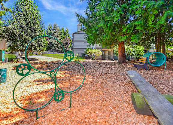 A playground with a green metal structure and a bench.
