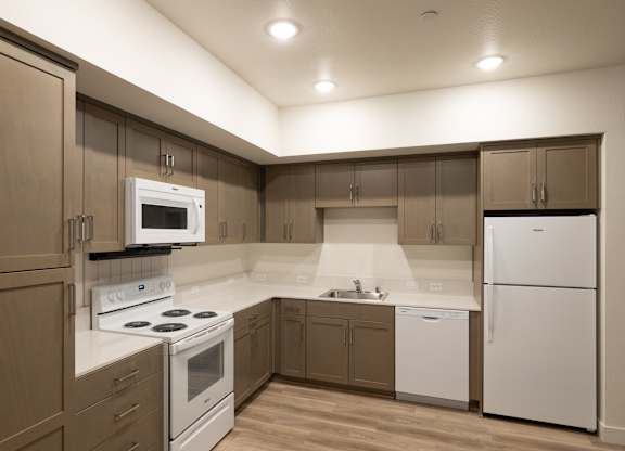 A kitchen with brown cabinets and white appliances.