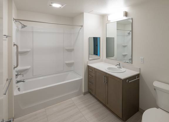 A white bathroom with a white toilet, a white sink, and a white bathtub.