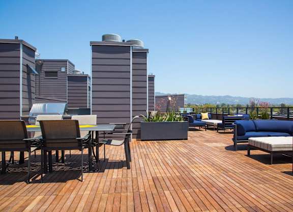 A wooden deck with chairs and a table at View Point Apartments, Berkeley, CA