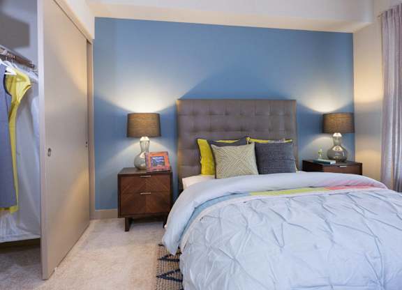 A bedroom with a bed, nightstands, and a window at View Point Apartments, Berkeley California