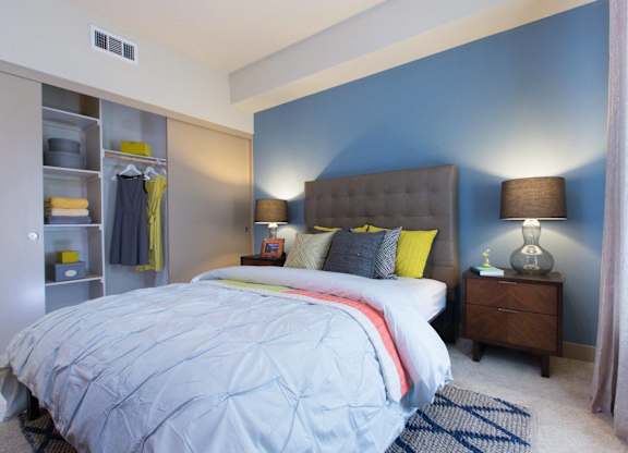 A bedroom with a large bed and a nightstand with a lamp at View Point Apartments, Berkeley, CA