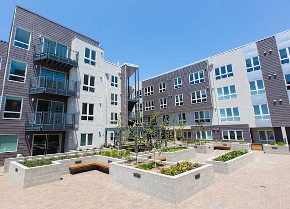A modern apartment complex with a courtyard in the foreground at View Point Apartments, Berkeley, CA, 94710
