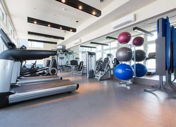 A gym with treadmills, exercise balls, and other equipment at View Point Apartments, California, 94710