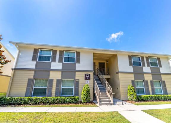 A two-story apartment building with a staircase leading to the entrance at Academy on Dean Woods Apartments, Orlando, FL