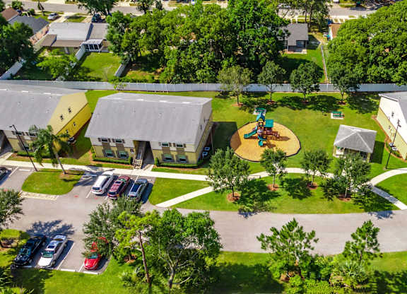 A playground in the middle of a residential area with houses on either side at Academy on Dean Woods Apartments, Orlando, 32825