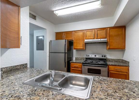 A kitchen with granite countertops and stainless steel appliances. at Academy on Dean Woods Apartments, Orlando, FL, 32825