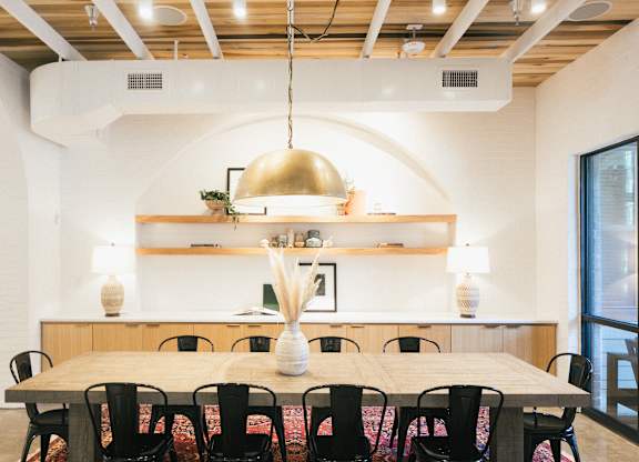 A dining room with a wooden table and chairs.