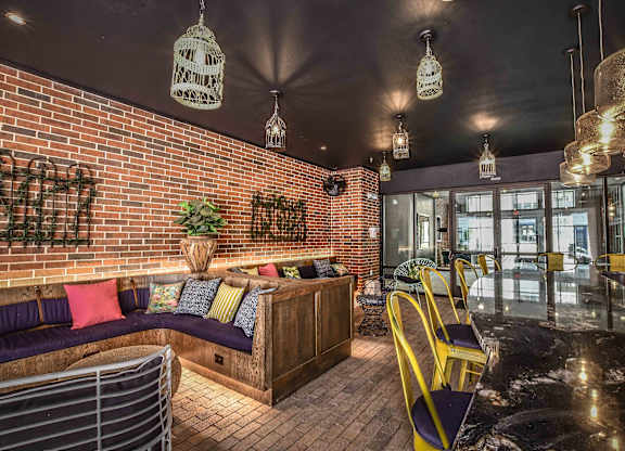 A cozy indoor seating area with a brick wall and hanging light fixtures.