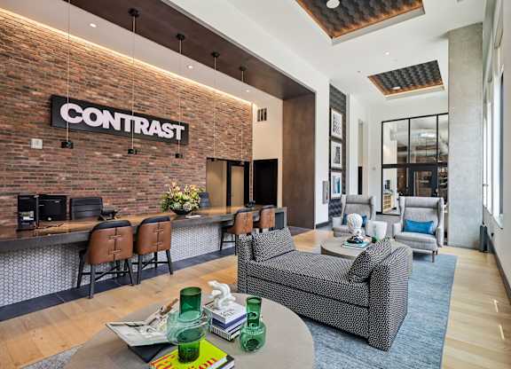 A living room with a brick wall and a sign that says "CONTRAST".