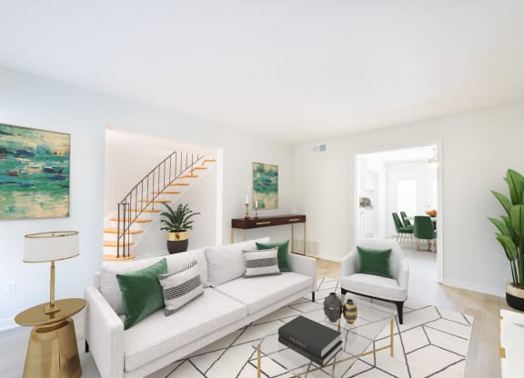 a living room with a white couch and green pillows