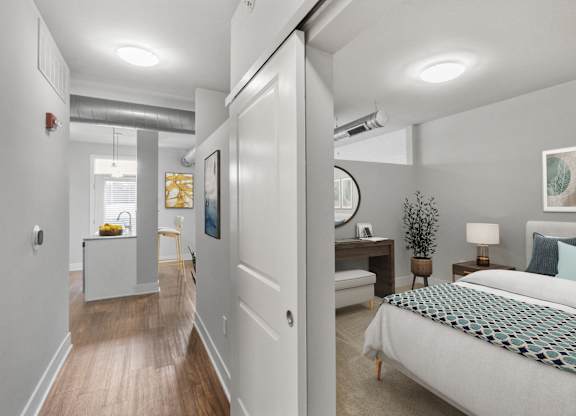 A bedroom with a bed, nightstand, and lamp at CityWay Apartments, Indianapolis, Indiana