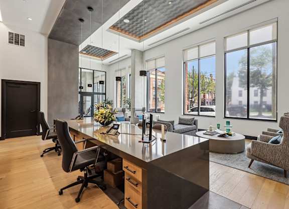 A modern home office with a large desk and chairs.