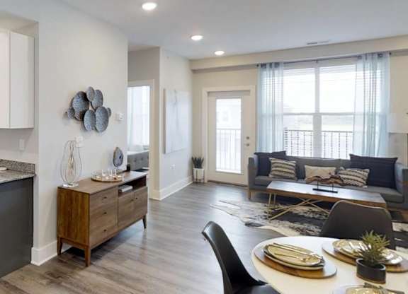 an open kitchen and living room with a table and chairs at Echo Park at Perry Crossing Apartments, Indiana