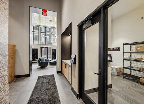 A black door with a glass window and a sign that says "EXIT" is in the center of a hallway.