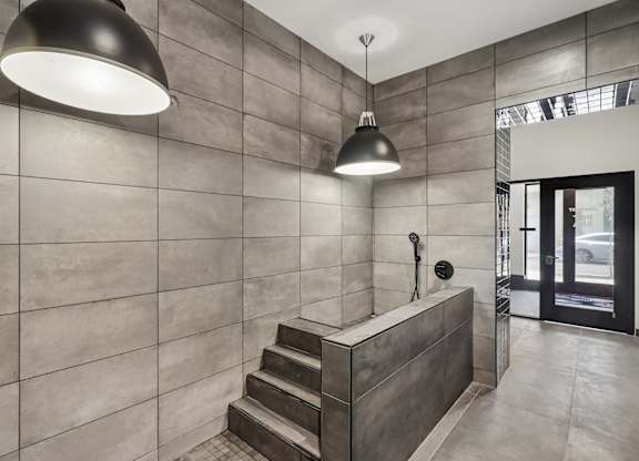 A modern bathroom with a concrete wall and a concrete staircase.