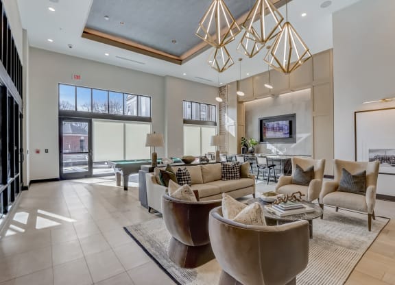 a living room with couches and chairs and a table and a pool