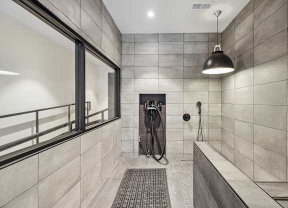 A modern bathroom with a walk-in shower and a window.