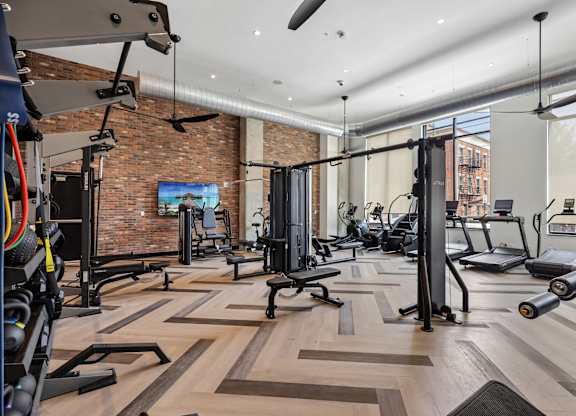 A gym with a brick wall and wooden floors.