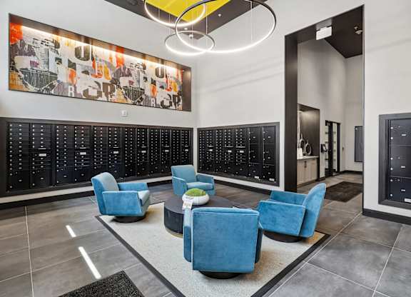 A modern waiting area with blue chairs and a large artwork on the wall.