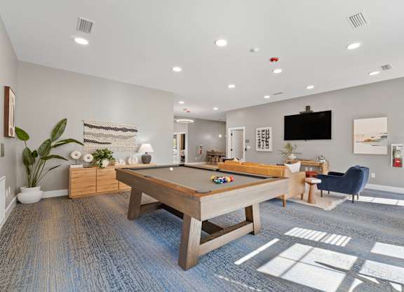 A room with a pool table and a television.