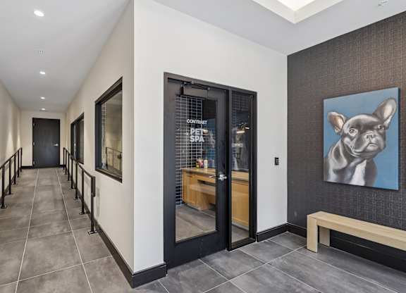 A hallway with a bench and a painting of a dog on the wall.