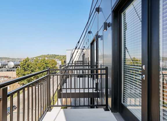 Private balcony at Contrast OTR apartments in Cincinnati, OH with sleek glass doors and city views.